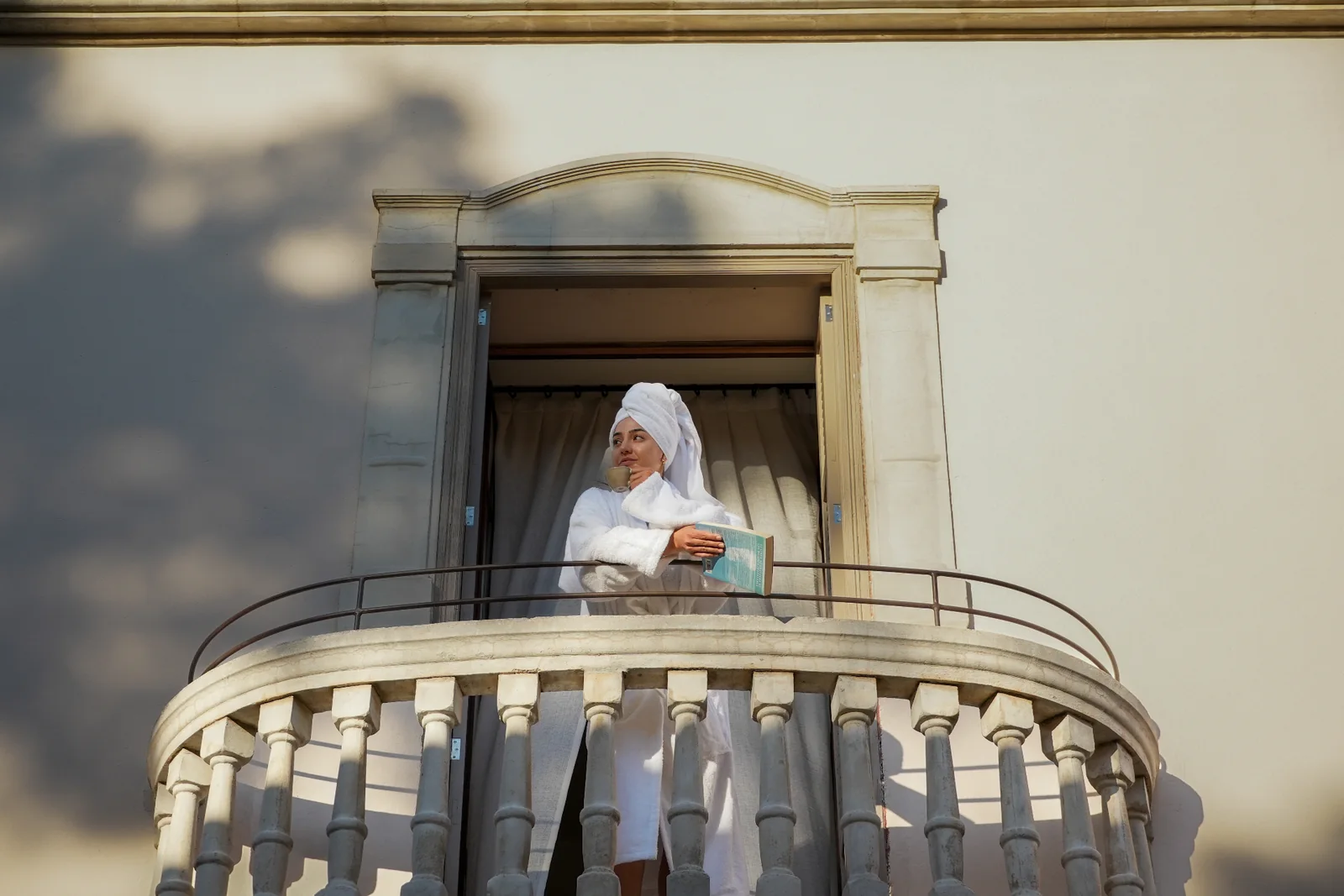Guest on a stone balcony at BYTRA Boutique Hotel