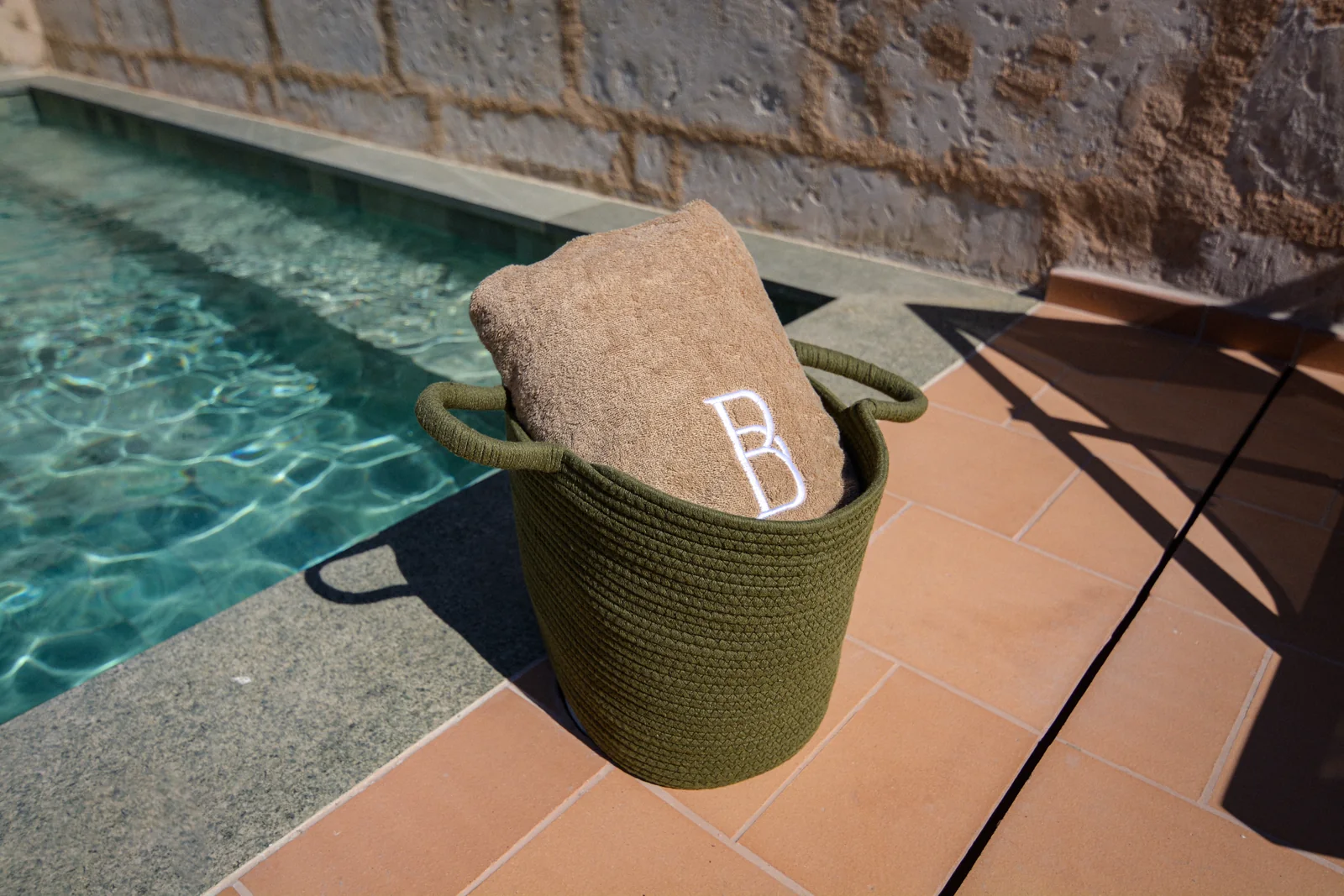 Monogrammed BYTRA towel by the pool